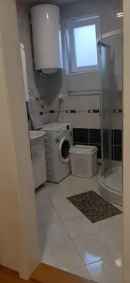 a bathroom with a washing machine and a glass shower at Apartman Andjela in Soko Banja