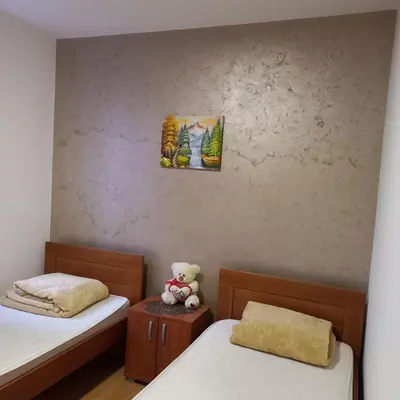 a small room with two beds and a teddy bear at Apartman Andjela in Soko Banja