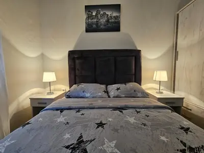a bedroom with a large bed with stars on it at Apartman Emma Vrnjačka Banja in Vrnjačka Banja