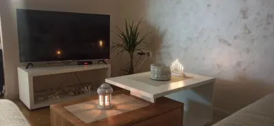 a living room with a television and a table with candles at Apartman Emma Vrnjačka Banja in Vrnjačka Banja