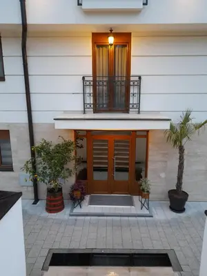 a house with a wooden door and a balcony at Apartman Emma Vrnjačka Banja in Vrnjačka Banja