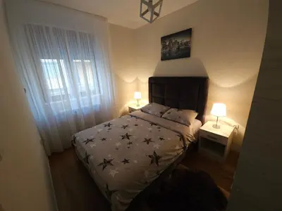 a bedroom with a bed and two lamps and a window at Apartman Emma Vrnjačka Banja in Vrnjačka Banja