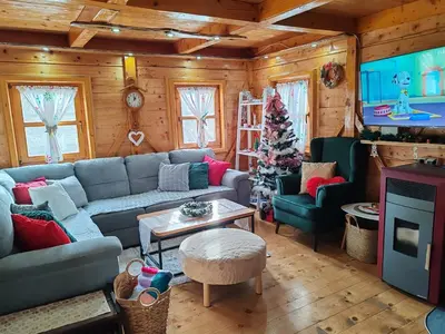a living room with a couch and a christmas tree at Vikendica Darija in Kraljevo