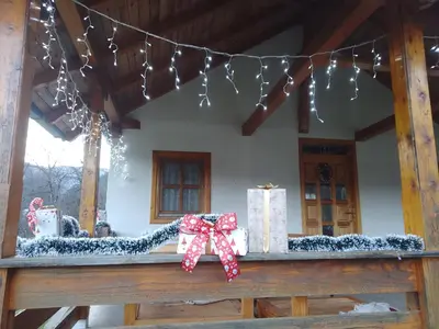 a porch with presents on a table with christmas lights at Vikendica Darija in Kraljevo