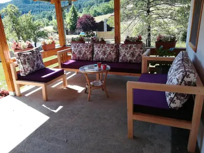 a porch with couches and a table and chairs at Vikendica Darija in Kraljevo