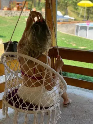a young girl sitting in a swing at Vikendica Darija in Kraljevo