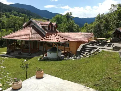 a small house with a large roof on a yard at Vikendica Darija in Kraljevo