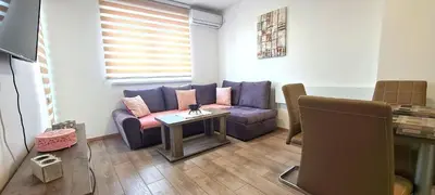 a living room with a purple couch and a table at Apartmani Lavanda in Soko Banja