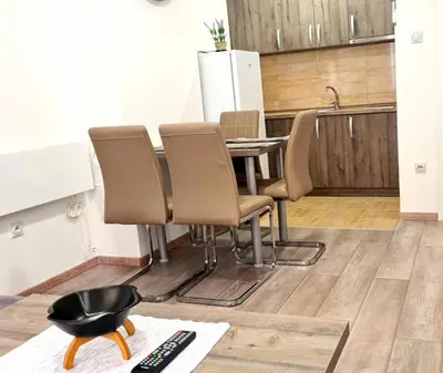 a kitchen with a table and chairs and a remote control at Apartmani Lavanda in Soko Banja