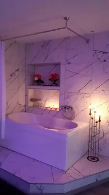 a white bathroom with a tub with candles in it at FARAON pn 1 in Paraćin