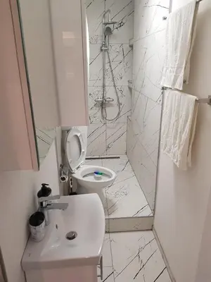 a white bathroom with a toilet and a sink at FARAON pn 1 in Paraćin