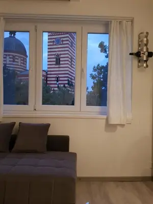 a living room with a couch in front of two windows at FARAON pn 1 in Paraćin