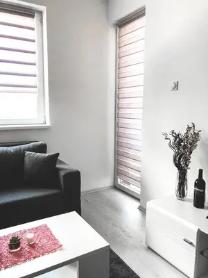 a living room with a black couch and a white table at Apartman DEA in Soko Banja