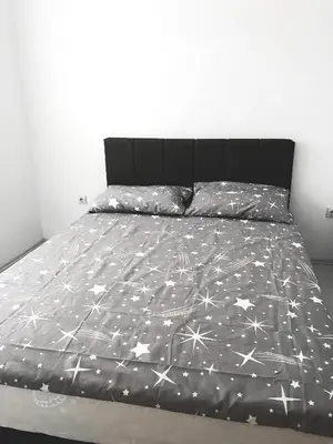 a bed with a black comforter with stars on it at Apartman DEA in Soko Banja
