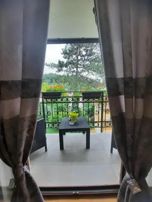 a table with a vase on top of a balcony at Apartman Korićanac Vrnjačka Banja in Vrnjačka Banja