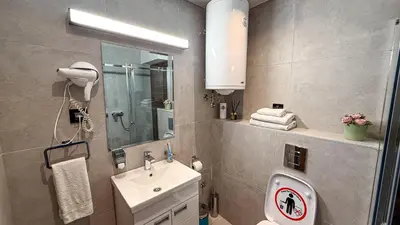 a bathroom with a sink and a toilet and a mirror at Zoned MASLAČAK lux - SPA & Wellness Kopaonik in Kopaonik