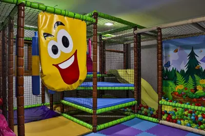 a play room with a play structure with a slide at Zoned MASLAČAK lux - SPA & Wellness Kopaonik in Kopaonik