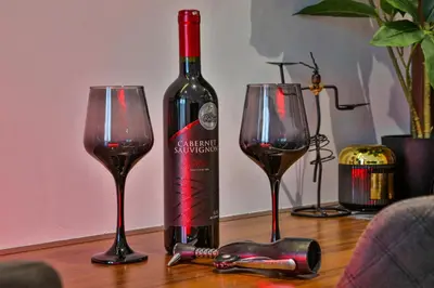 a bottle of wine and two glasses on a table at Zoned MASLAČAK lux - SPA & Wellness Kopaonik in Kopaonik