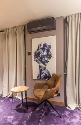 a chair and a table in a room with curtains at Elite Space in Niš