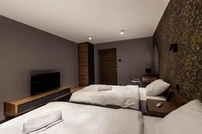 a hotel room with two beds and a flat screen tv at Elite Space in Niš