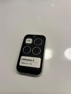 a black remote control sitting on a white table at Elite Space in Niš