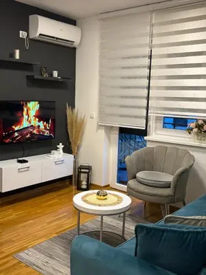 a living room with a couch and a table and a tv at Apartman Korać in Vrnjačka Banja