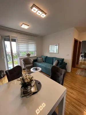 a living room with a blue couch and a table at Apartman Korać in Vrnjačka Banja