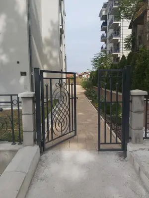 a gate to a building with a walkway at Apartman Korać in Vrnjačka Banja