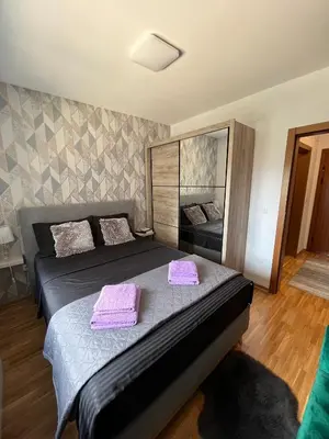 a bedroom with a bed with purple towels on it at Apartman Korać in Vrnjačka Banja