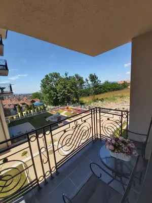 a balcony with a table and a view of a park at Apartman Korać in Vrnjačka Banja