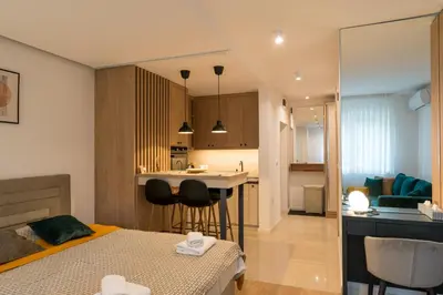 a bedroom with a bed and a kitchen and a living room at Apartman Sandra Free parkig in Vrnjačka Banja