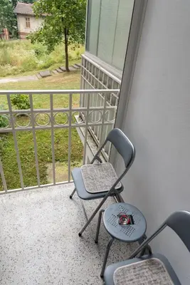 two chairs sitting on a balcony with a view at Apartman Sandra Free parkig in Vrnjačka Banja