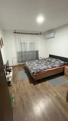 a bedroom with a bed and a window with rugs at villa Antonijevic in Brestovac