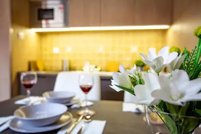 a table with glasses of red wine and white flowers at Zen apartman in Kopaonik