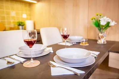 a table with two glasses of wine on it at Zen apartman in Kopaonik