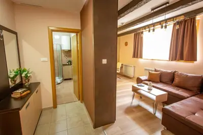 a living room with a couch and a table at Zen apartman in Kopaonik