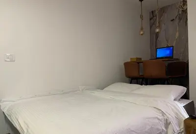 a bedroom with a white bed and a computer on a desk at Mr Alek - Luxury Apartment Kopaonik in Kopaonik