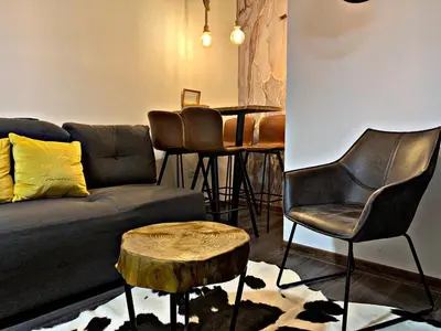 a living room with a couch and a table with chairs at Mr Alek - Luxury Apartment Kopaonik in Kopaonik