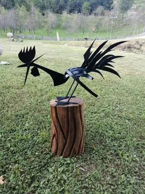 a bird sculpture sitting on top of a tree stump at Galerija68 in Kraljevo