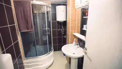 a small bathroom with a sink and a shower at Aber Apartmani Kopaonik in Kopaonik
