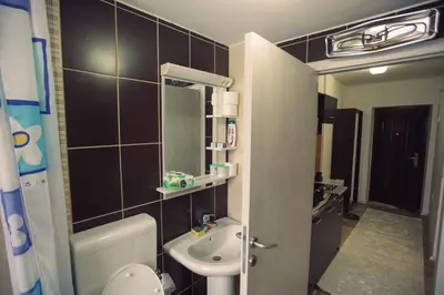 a bathroom with a sink and a toilet and a mirror at Aber Apartmani Kopaonik in Kopaonik