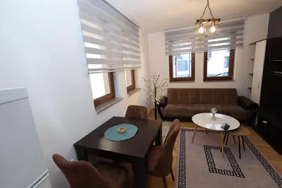 a living room with a table and a couch at Aber Apartmani Kopaonik in Kopaonik
