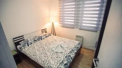 a bedroom with a bed with a dress on it at Aber Apartmani Kopaonik in Kopaonik