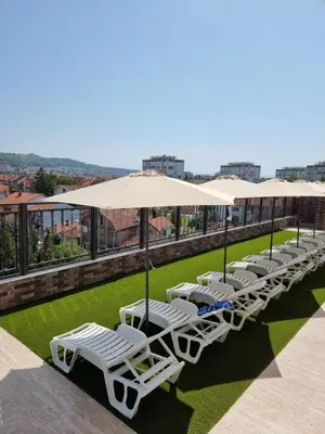 a row of lounge chairs and umbrellas on a roof at Sky apartmani & spa-Vip Lux DOO in Leskovac