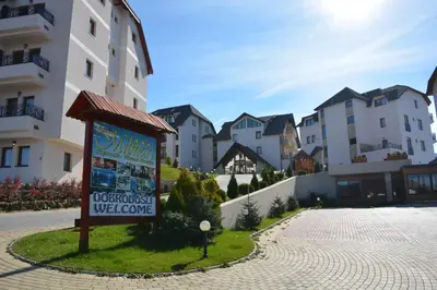 a sign in front of a group of houses at Milmari - Breakfast and pool in Kopaonik