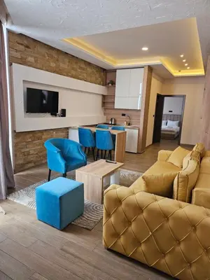 a living room with a couch and blue chairs at Milmari - Breakfast and pool in Kopaonik