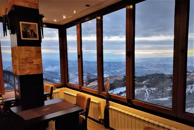 a room with a table and a view of the mountains at Milmari - Breakfast and pool in Kopaonik