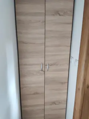 a wooden cabinet with silver knobs on it at Studios Šumska Kuća 2 & 3 in Kopaonik