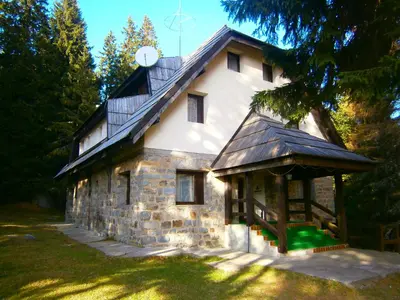 a stone house with a gambrel roof at Studios Šumska Kuća 1 in Kopaonik