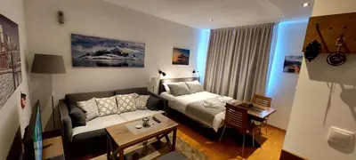 a room with a bed and a table and a couch at Brzeće Center Studio Mitrovski Gondola 300m in Kopaonik